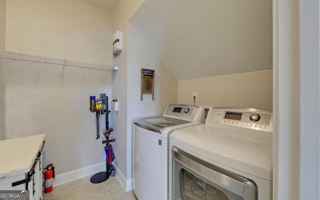 laundry area featuring light tile patterned floors, baseboards, washing machine and dryer, and laundry area