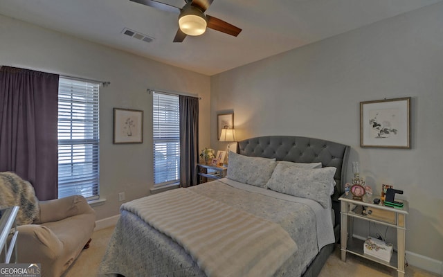 carpeted bedroom with visible vents, ceiling fan, and baseboards