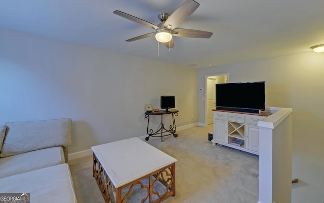 living area featuring light carpet, baseboards, and ceiling fan