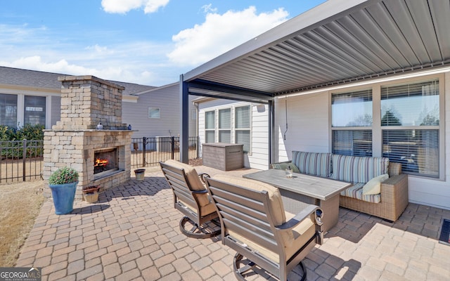 view of patio / terrace featuring an outdoor stone fireplace and fence