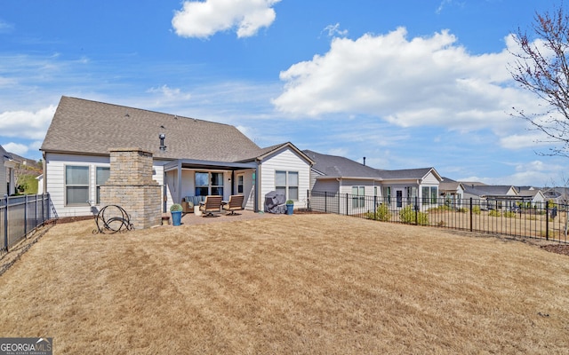 rear view of property with a patio area, fence, a residential view, and a lawn