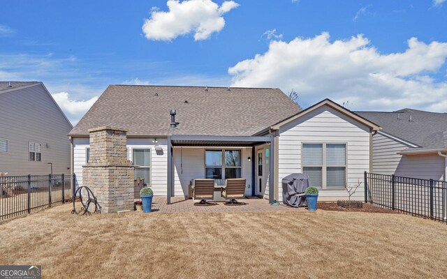 back of property with a patio, a lawn, a fenced backyard, and a shingled roof