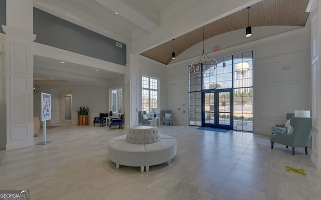 interior space featuring high vaulted ceiling, a notable chandelier, french doors, a decorative wall, and wood ceiling