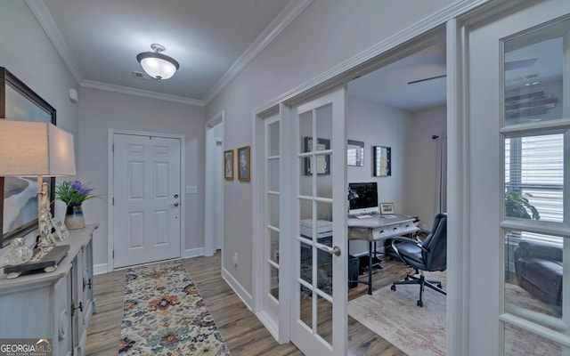 foyer with wood finished floors, visible vents, baseboards, ornamental molding, and french doors