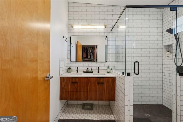 bathroom featuring vanity, tile patterned flooring, a stall shower, and backsplash