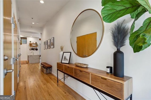 hallway featuring recessed lighting, baseboards, and light wood-style flooring