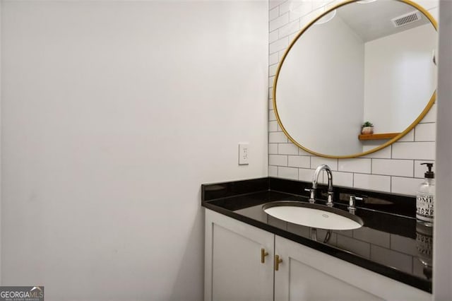 bathroom featuring visible vents, vanity, and decorative backsplash