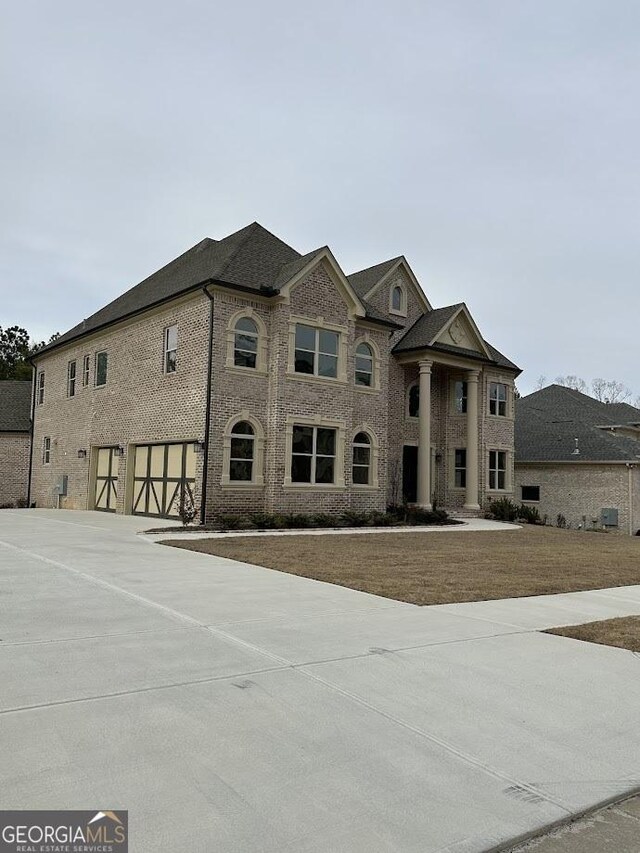 view of front of home with a garage, brick siding, and concrete driveway