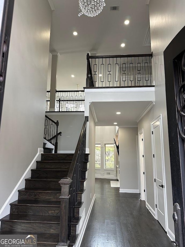 stairs featuring wood finished floors, visible vents, baseboards, recessed lighting, and ornamental molding