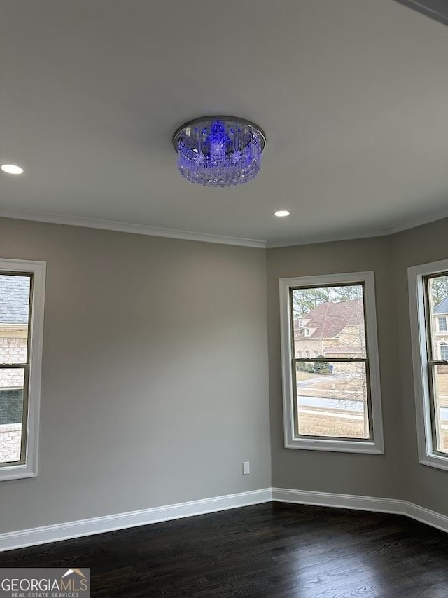 spare room featuring dark wood-type flooring, recessed lighting, crown molding, and baseboards