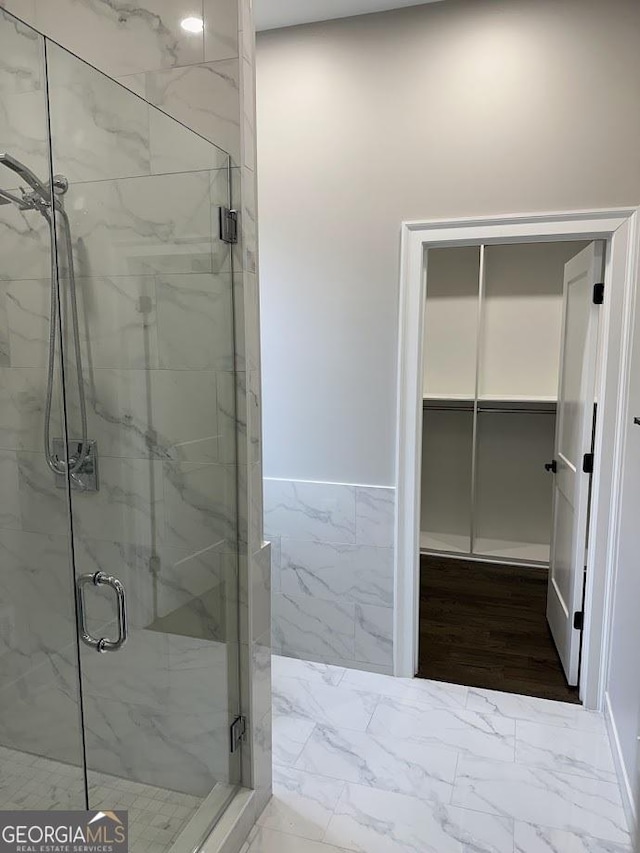 bathroom featuring a marble finish shower and marble finish floor