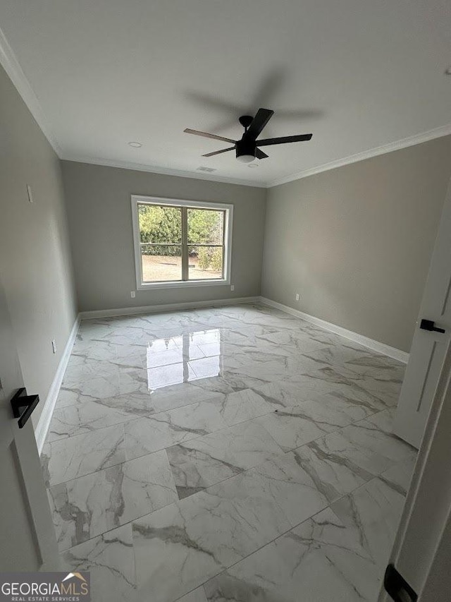 unfurnished room featuring crown molding, baseboards, and marble finish floor