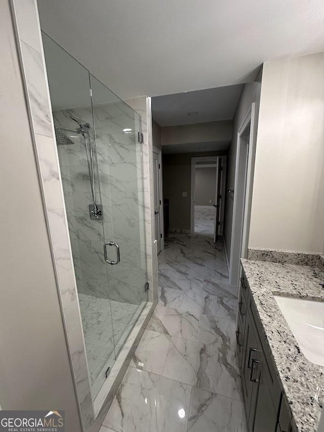 bathroom featuring a marble finish shower, marble finish floor, and vanity