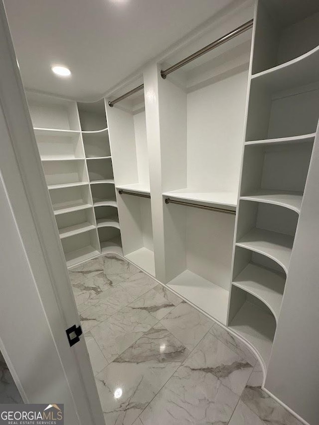 walk in closet with marble finish floor