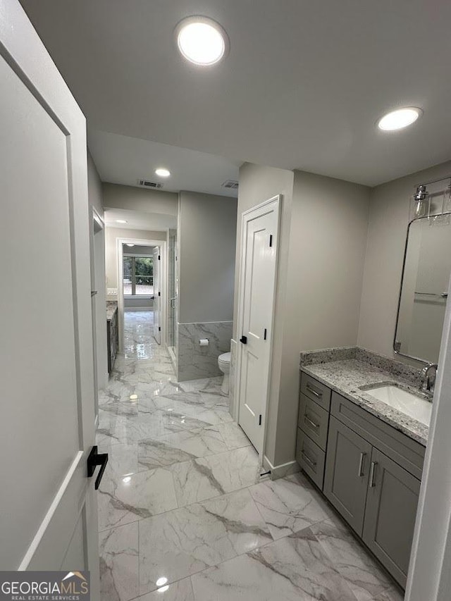 bathroom featuring vanity, toilet, visible vents, and marble finish floor