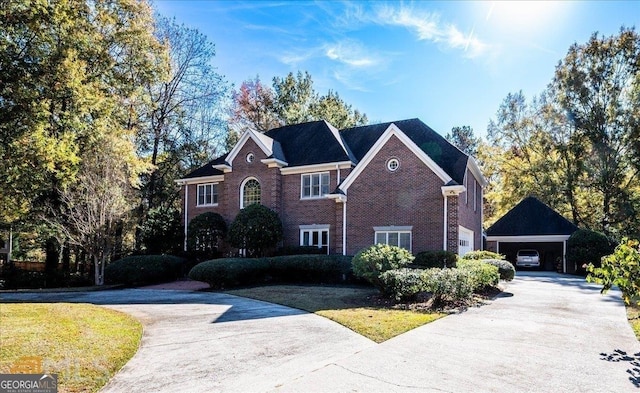 view of front of home with a detached carport, concrete driveway, brick siding, and a front lawn