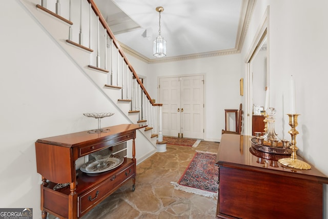 entryway featuring stairway, baseboards, ornamental molding, and stone finish floor