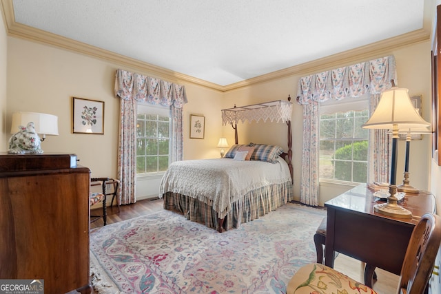 bedroom with wood finished floors and crown molding