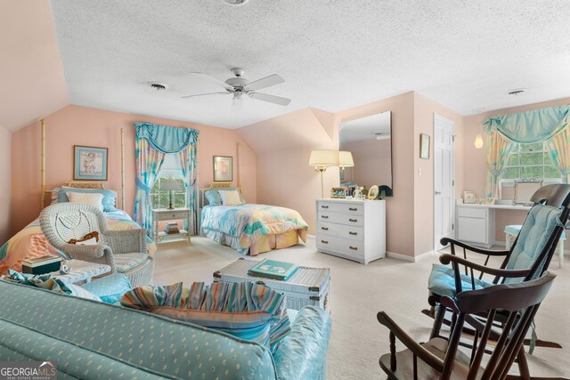 carpeted bedroom featuring a ceiling fan, baseboards, visible vents, vaulted ceiling, and a textured ceiling