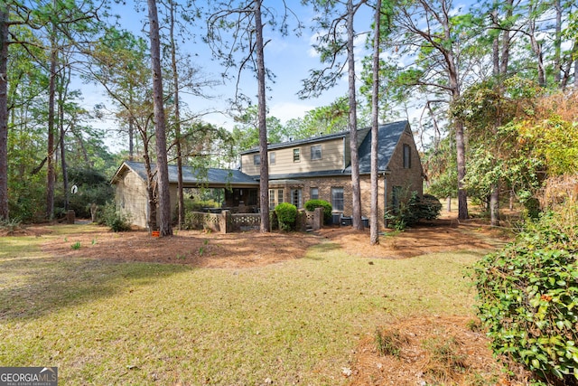 back of property featuring brick siding and a lawn