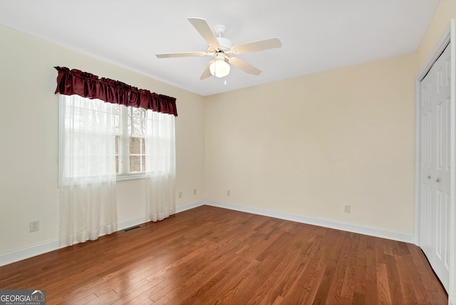 empty room with visible vents, baseboards, a ceiling fan, and hardwood / wood-style floors