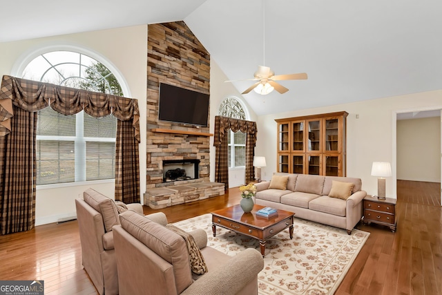 living room with a wealth of natural light, a ceiling fan, and hardwood / wood-style flooring