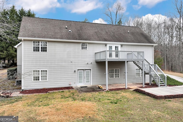 rear view of property featuring stairway, a lawn, and french doors