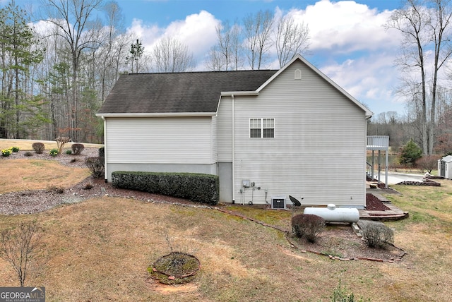 view of home's exterior featuring a shingled roof and a yard