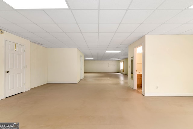 basement featuring a drop ceiling and baseboards