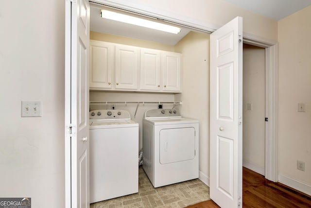 laundry room featuring baseboards, cabinet space, and independent washer and dryer