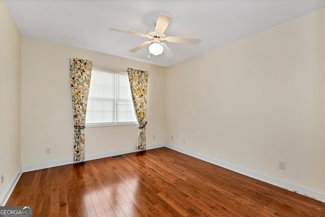 unfurnished room with visible vents, wood-type flooring, baseboards, and ceiling fan