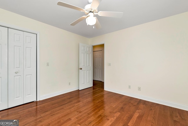 unfurnished bedroom featuring a closet, baseboards, wood finished floors, and a ceiling fan