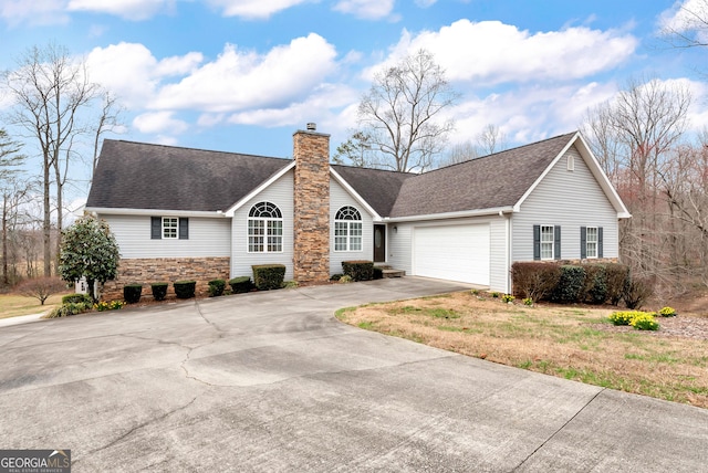 ranch-style home featuring a chimney, driveway, an attached garage, and a shingled roof