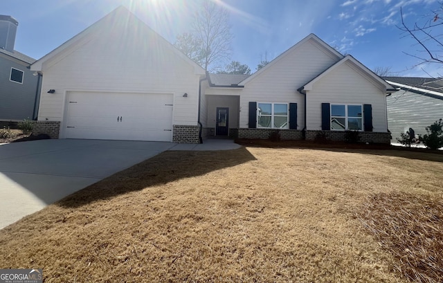 single story home featuring concrete driveway, an attached garage, brick siding, and a front lawn