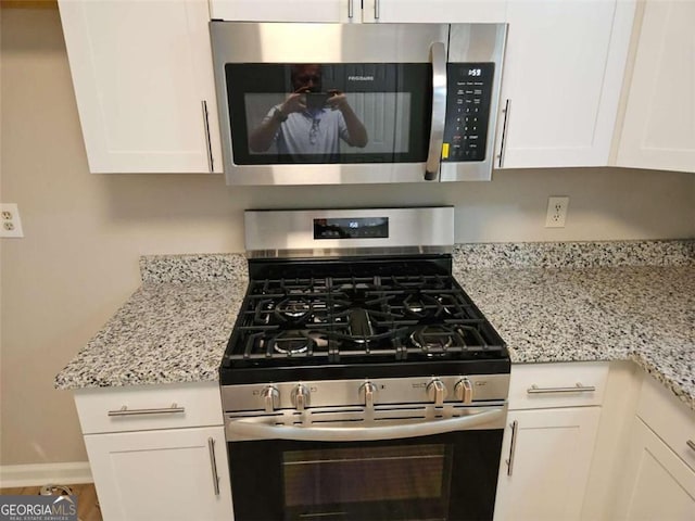147 Mildred Ct, Dallas, GA 30157 - kitchen featuring appliances with stainless steel finishes, white cabinets, and light stone countertops