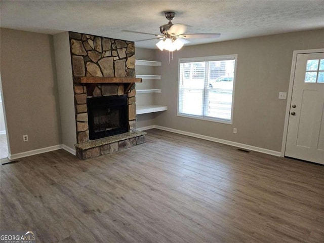 147 Mildred Ct, Dallas, GA 30157 - unfurnished living room with a textured ceiling, wood finished floors, a ceiling fan, built in features, and a fireplace
