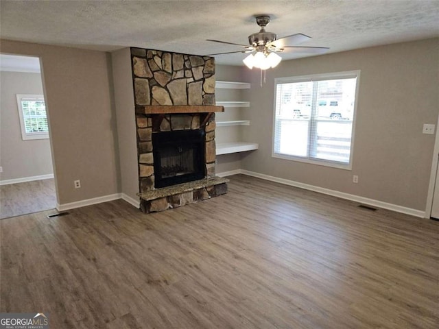 147 Mildred Ct, Dallas, GA 30157 - unfurnished living room featuring a textured ceiling, wood finished floors, built in features, ceiling fan, and a fireplace