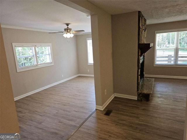 147 Mildred Ct, Dallas, GA 30157 - unfurnished living room featuring a fireplace with raised hearth, dark wood-style floors, a ceiling fan, and ornamental molding