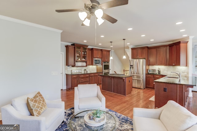 living room with crown molding, a toaster, light wood-style floors, and ceiling fan