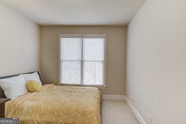 bedroom featuring light colored carpet and baseboards