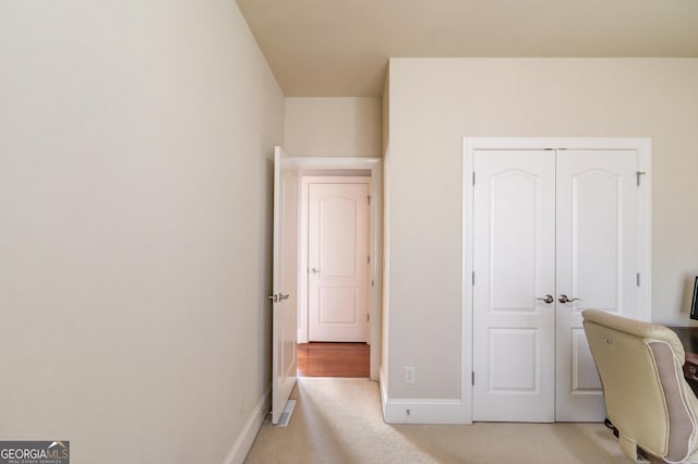 office with baseboards and light carpet