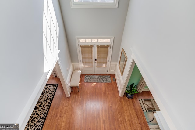 foyer featuring plenty of natural light, a decorative wall, visible vents, and wood finished floors