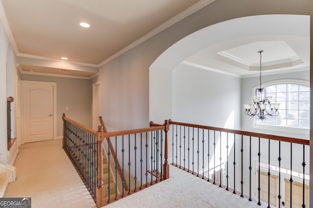 hallway with carpet flooring, crown molding, and a raised ceiling