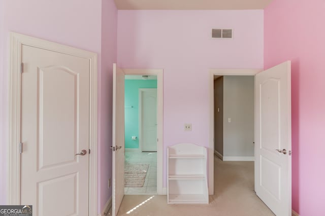 unfurnished bedroom featuring light colored carpet, visible vents, and baseboards