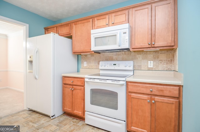 kitchen with white appliances, backsplash, and light countertops