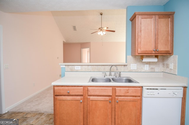 kitchen featuring a ceiling fan, a sink, tasteful backsplash, white dishwasher, and light countertops