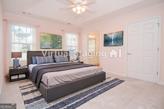 bedroom featuring baseboards, visible vents, a tray ceiling, ornamental molding, and light carpet