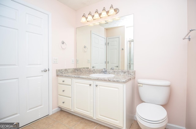 full bath with toilet, baseboards, tile patterned flooring, and vanity