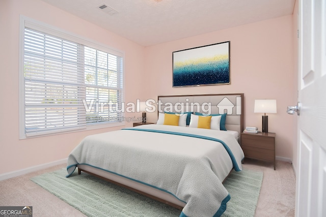 carpeted bedroom with visible vents and baseboards