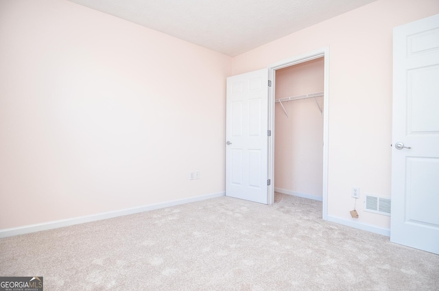 unfurnished bedroom featuring visible vents, baseboards, carpet, and a closet